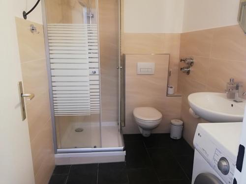 a bathroom with a shower and a toilet and a sink at The Hostel in Hamburg