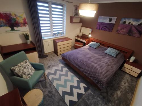 a bedroom with a bed and a chair and a table at City Center Apartment in Słupsk