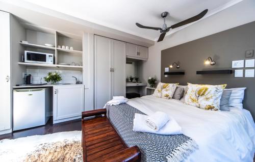 a bedroom with a large bed and a kitchen at Craigivar Guesthouse in Pretoria