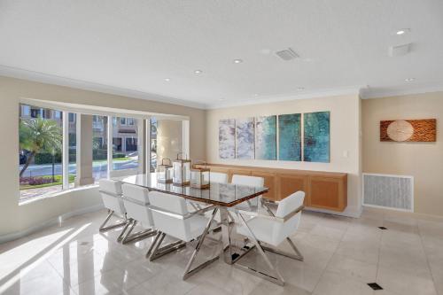 a dining room with a glass table and white chairs at Palms by the Sea Villa in Fort Lauderdale