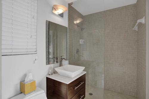 a bathroom with a sink and a toilet and a mirror at Palms by the Sea Villa in Fort Lauderdale