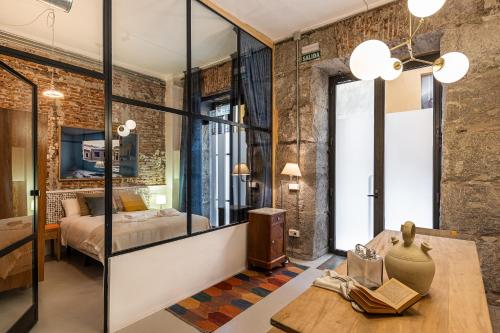 a bedroom with a bed and a room with a table at BNBHolder Art Loft LA LATINA in Madrid