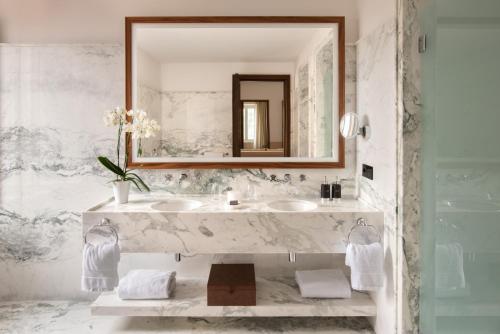 San Domenico Palace, Taormina, A Four Seasons Hotel في تاورمينا: حمام مع حوض من الرخام ومرآة