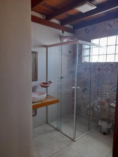 a bathroom with a glass shower and a sink at Mama Africa Hostel in Florianópolis