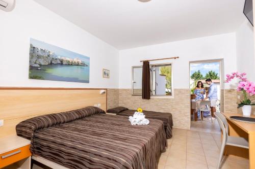 una camera d'albergo con un letto grande e un tavolo di Albergo Torrente a Vieste