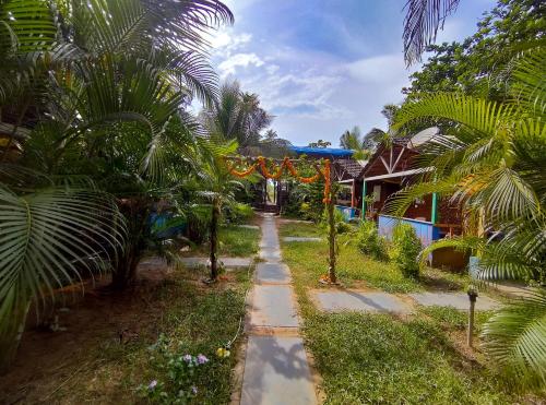 a path in front of a house with palm trees at Secret Garden Arambol in Arambol