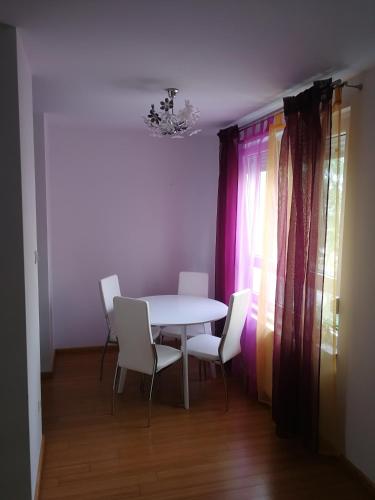 uma sala de jantar com uma mesa branca e cadeiras em Iver apartman em Sesvete