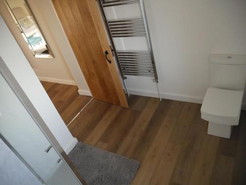 a bathroom with a toilet and a wooden floor at The Fox and Hounds in Whittlebury