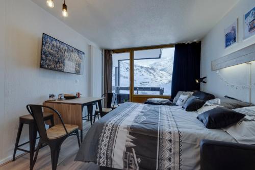 1 dormitorio con cama, escritorio y ventana en Au 3ème ciel Tignes - Vue Lac & Montagnes - Proche pistes - Idéal 2 adultes + 2 enfants en Tignes