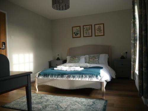 um quarto com uma cama com um cobertor azul em The Fox and Hounds em Whittlebury