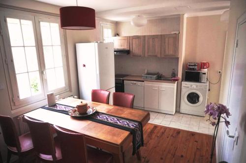 a kitchen with a table and a kitchen with a refrigerator at Apakabar Homestay, Gîte 6 personnes, proche gare Melun, parking privé in La Rochette