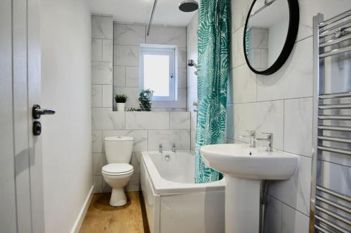 a bathroom with a sink and a toilet and a bath tub at Fotheringhay House By Horizon Stays in Darlington