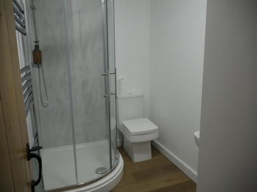 a bathroom with a toilet and a glass shower at The Fox and Hounds in Whittlebury