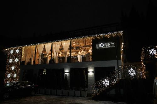 a building with christmas lights and a sign on it at Hotel Vedmezhyi Dvir in Bukovel