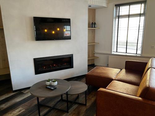 a living room with a couch and a fireplace at Hotel Nap in West-Terschelling