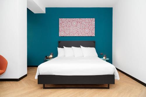 a bedroom with a large bed with a blue wall at CX Turin Belfiore Student&Explorer Place in Turin