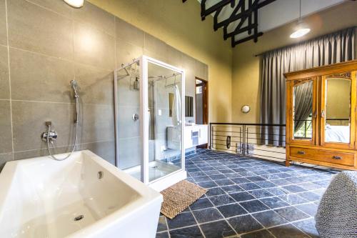 a large bathroom with a tub and a shower at Craigivar Guesthouse in Pretoria