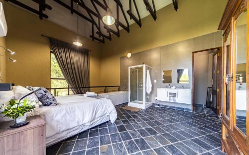 a bedroom with a large bed and a bathroom at Craigivar Guesthouse in Pretoria
