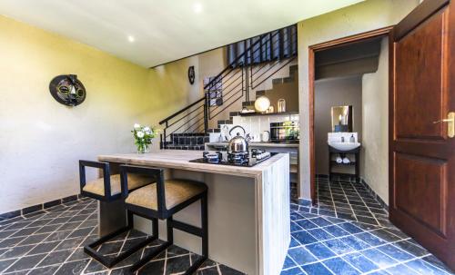 a kitchen with a counter with a sink and a staircase at Craigivar Guesthouse in Pretoria