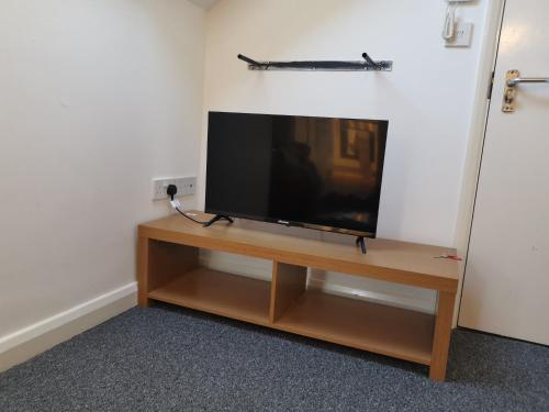 - une télévision à écran plat installée au-dessus d'un centre de divertissement en bois dans l'établissement Unique Studio III with free WIFI, à Maidstone