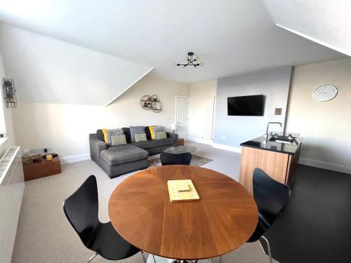 a living room with a table and a couch at Regal Retreat Modern 2 bed apartment 400m from sea in Cromer