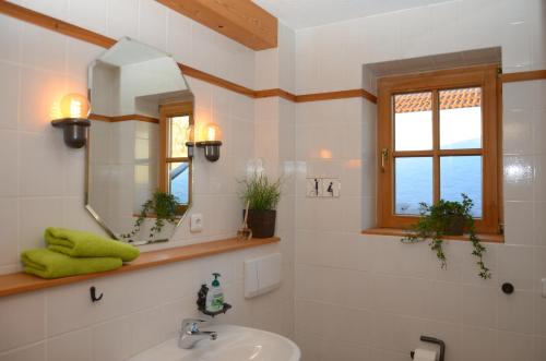 W łazience znajduje się umywalka i lustro. w obiekcie Ferienwohnung Haus Wuhrbichl w mieście Marquartstein
