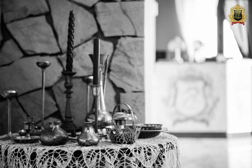 a table with a white lace table cloth and vases at Rezydencja Bakamus in Sandomierz