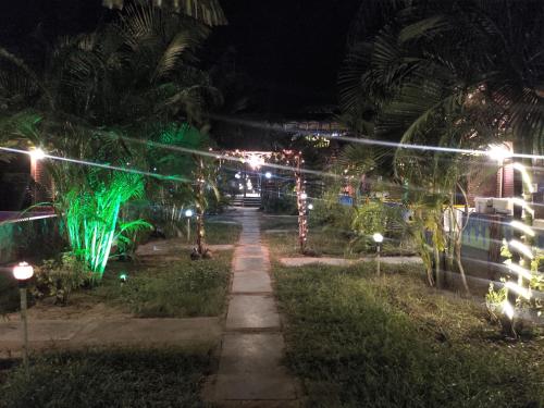 a walkway lit up at night with christmas lights at Secret Garden Arambol in Arambol