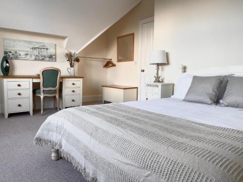 a bedroom with a bed and a desk and a chair at Regal Retreat Modern 2 bed apartment 400m from sea in Cromer