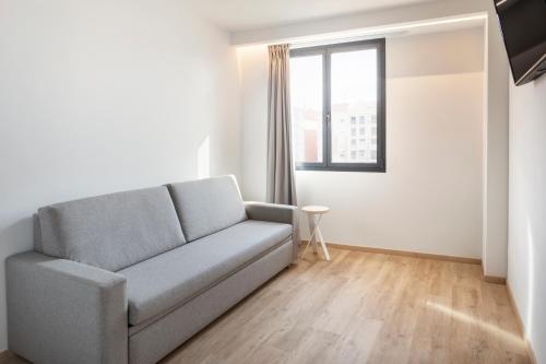 a living room with a couch and a window at B&B HOTEL Málaga Centro in Málaga