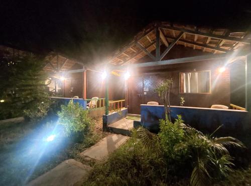 a house with lights on the side of it at night at Secret Garden Arambol in Arambol