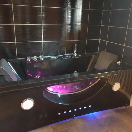 a bathtub with a pink tub in a bathroom at Les Nuances de Mélis' in Crémieu