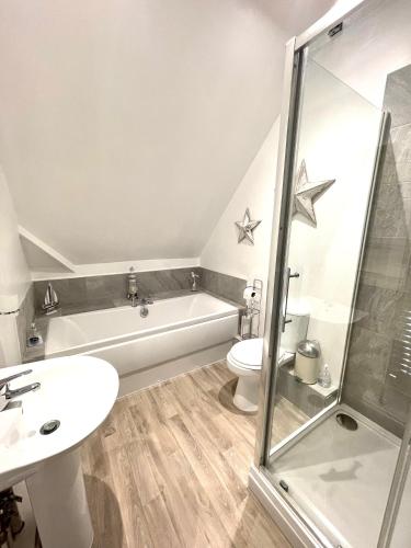a bathroom with a sink toilet and a bath tub at Regal Retreat Modern 2 bed apartment 400m from sea in Cromer