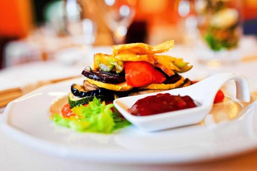 a plate of food with vegetables on a table at Zamek w Krasiczynie in Krasiczyn