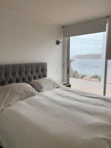 a bedroom with a large bed with a large window at Don Felix in Coquimbo