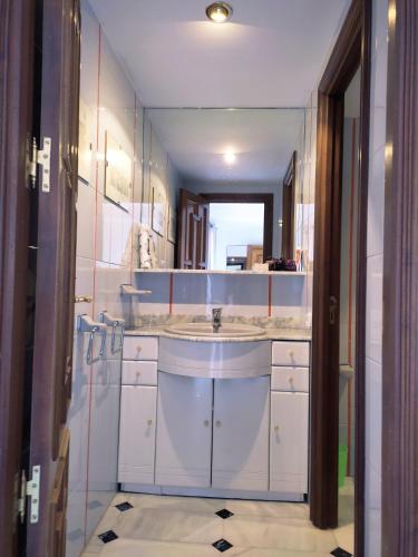 a white bathroom with a sink and a mirror at San Basilio´s Red House in Córdoba