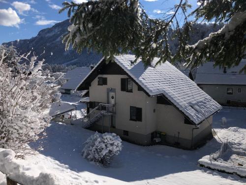 a house with snow on the roof of it at SavaDolinka House in Mojstrana