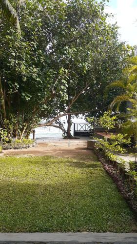 a park with a tree and a sandy beach at Beach Paradise in Matara