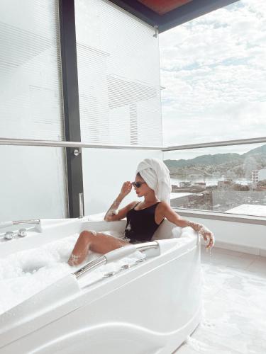 a woman sitting in a bath tub talking on a cell phone at Hotel Santorini in Guatapé