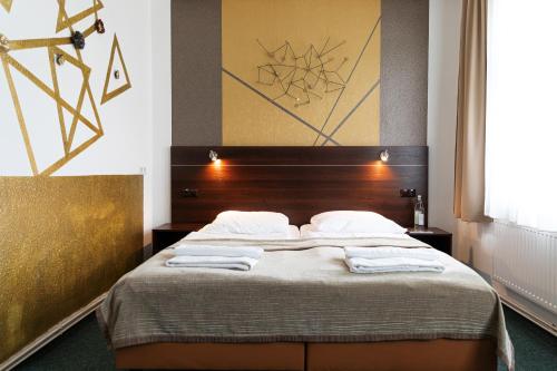 a bedroom with a bed with towels on it at Hotel Polonia - Frankfurt/Oder in Frankfurt/Oder