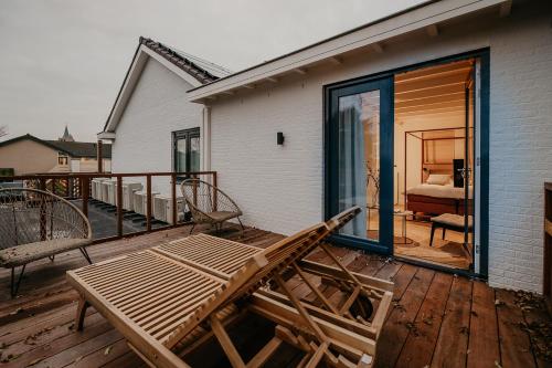 a deck with a bench and a bed and a bedroom at Villa Noordzee in Renesse