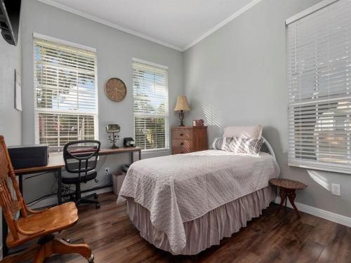 um quarto com uma cama, uma secretária e janelas em Cheerful 3 Bedroom Home with Loft em Dickinson