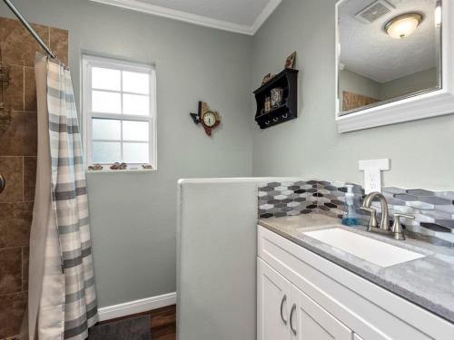 ein weißes Bad mit einem Waschbecken und einer Dusche in der Unterkunft Cheerful 3 Bedroom Home with Loft in Dickinson