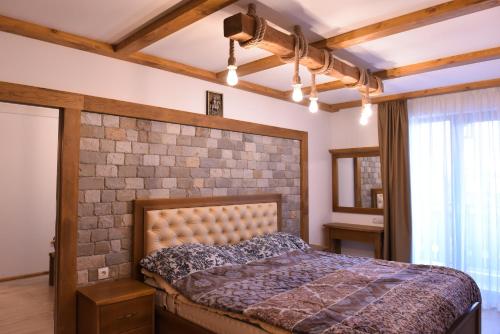 een slaapkamer met een bed en een bakstenen muur bij Лукс апартамент in Bansko