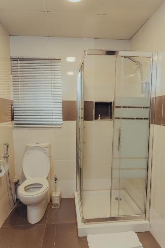 a bathroom with a toilet and a glass shower at Sinclair Lake Chad in Abuja