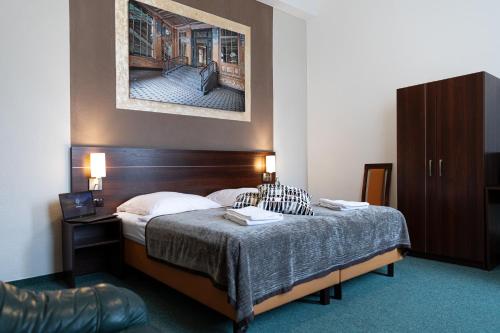 a hotel room with a bed and a cabinet at Hotel Polonia - Frankfurt/Oder in Frankfurt/Oder
