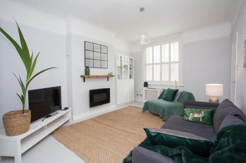 a living room with a couch and a tv at Foresters Cottage in Worthing
