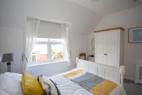a bedroom with a white bed and a window at Foresters Cottage in Worthing