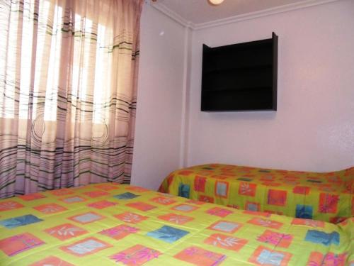 una camera con letto e TV a schermo piatto di Los Labradores a Peñíscola