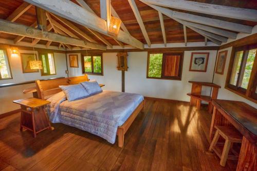 1 dormitorio con 1 cama y suelo de madera en Hotel Posada Los Destiladeros en Pedasí Town